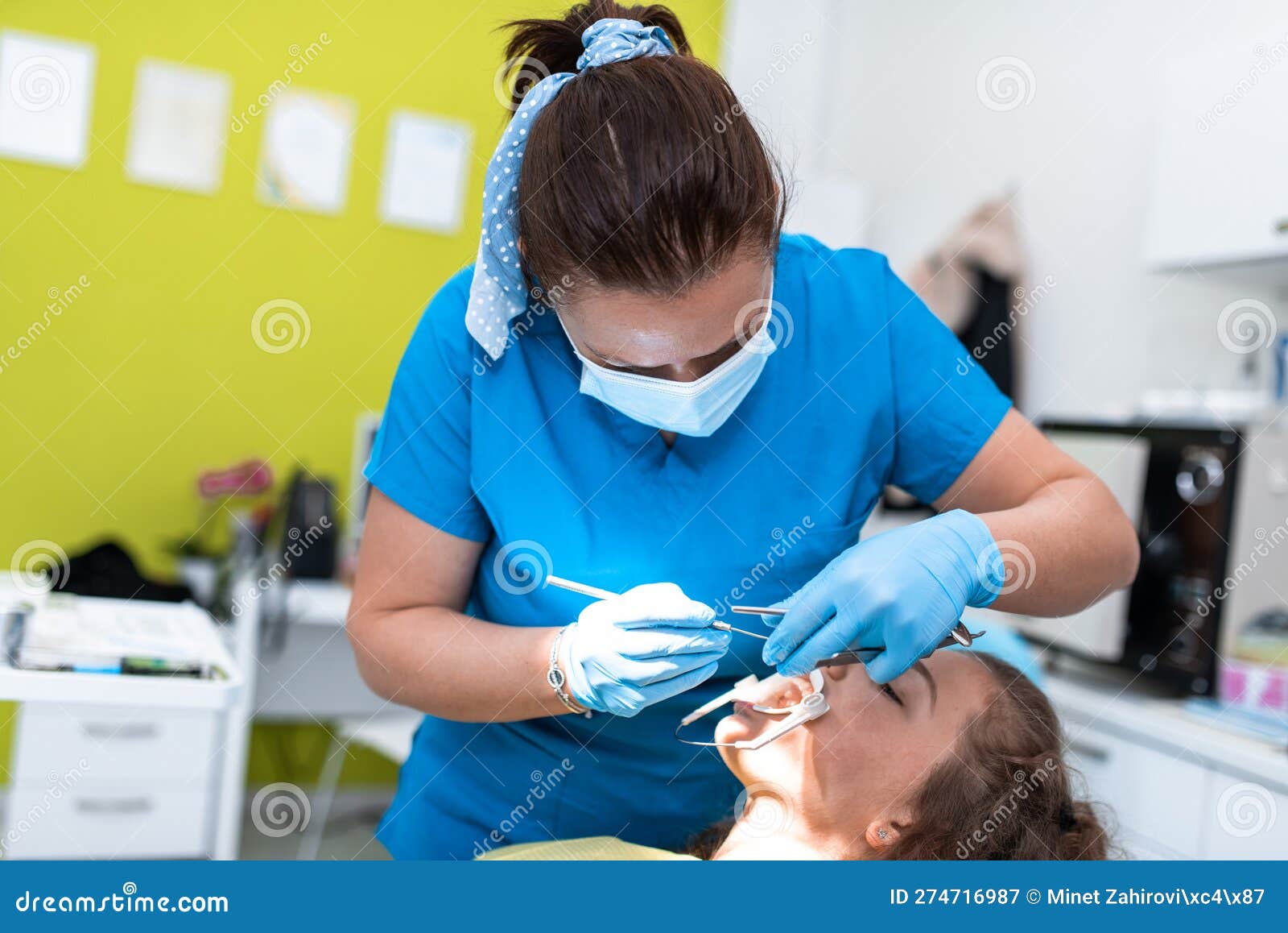 dentist appointment at a dental clinic, placing braces locks on the teeth and pulling the archwire to fix it