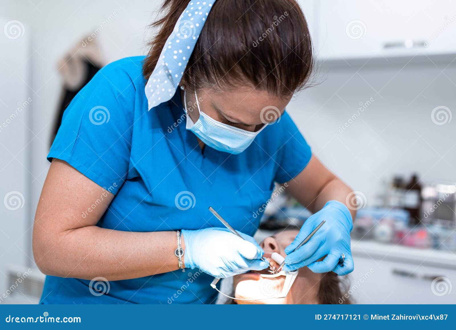 dentist appointment at a dental clinic, placing braces locks on the teeth and pulling the archwire to fix it