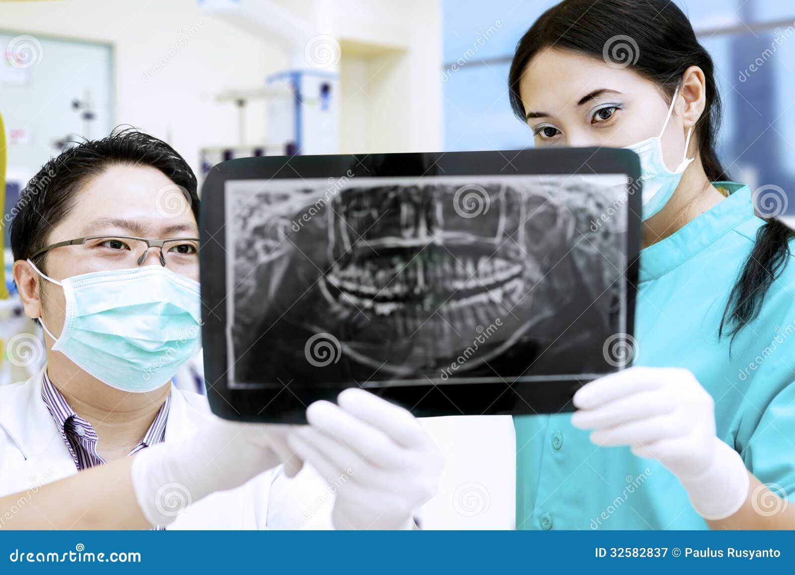 dentist and assistant analysing x-ray at dental clinic