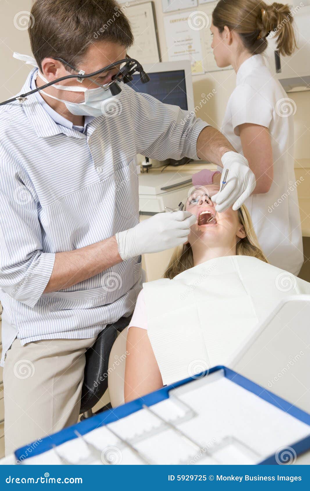 Dentist and Assistant in Exam Room with Woman Stock Image Image of