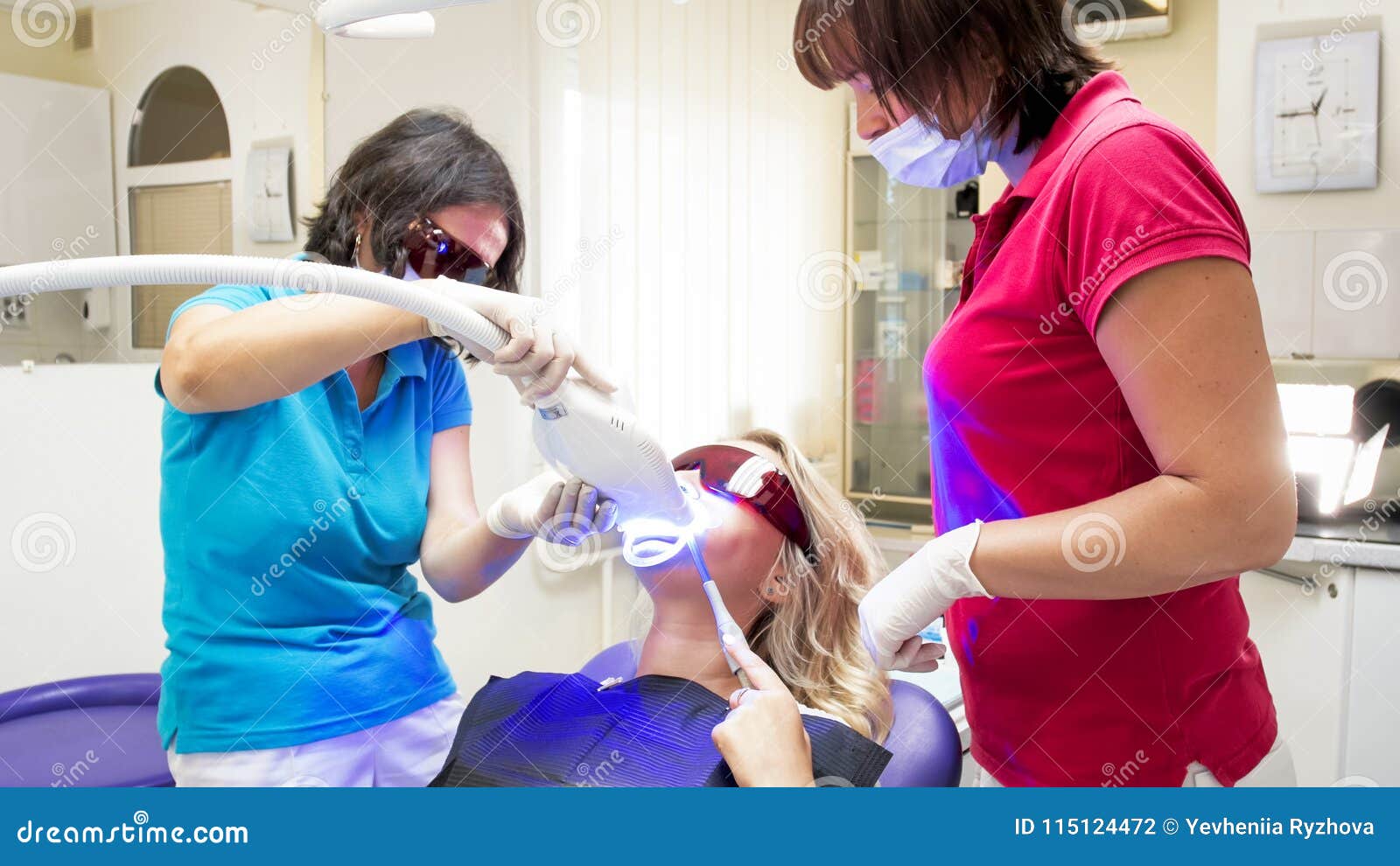 Dentist and Assistant in Protective Orange Glasses during Teeth
