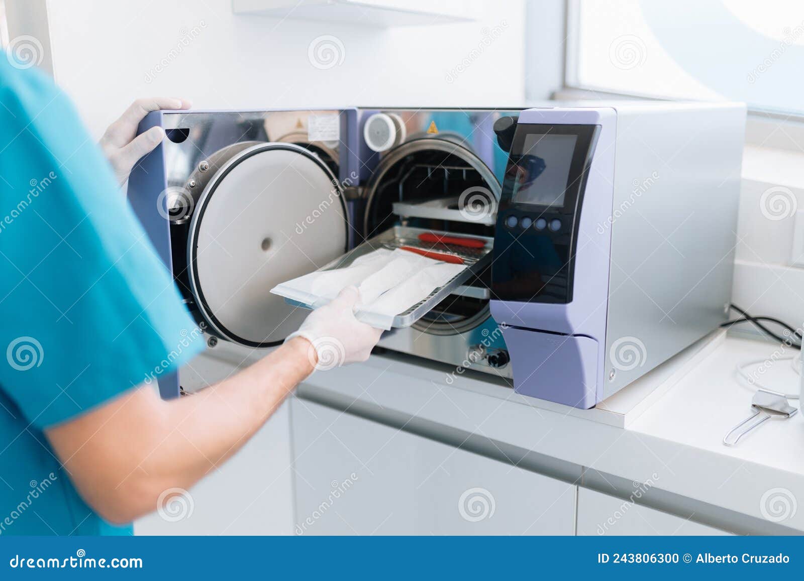Dentist Assistant Sterilizing Equipment in a Machine Stock Photo