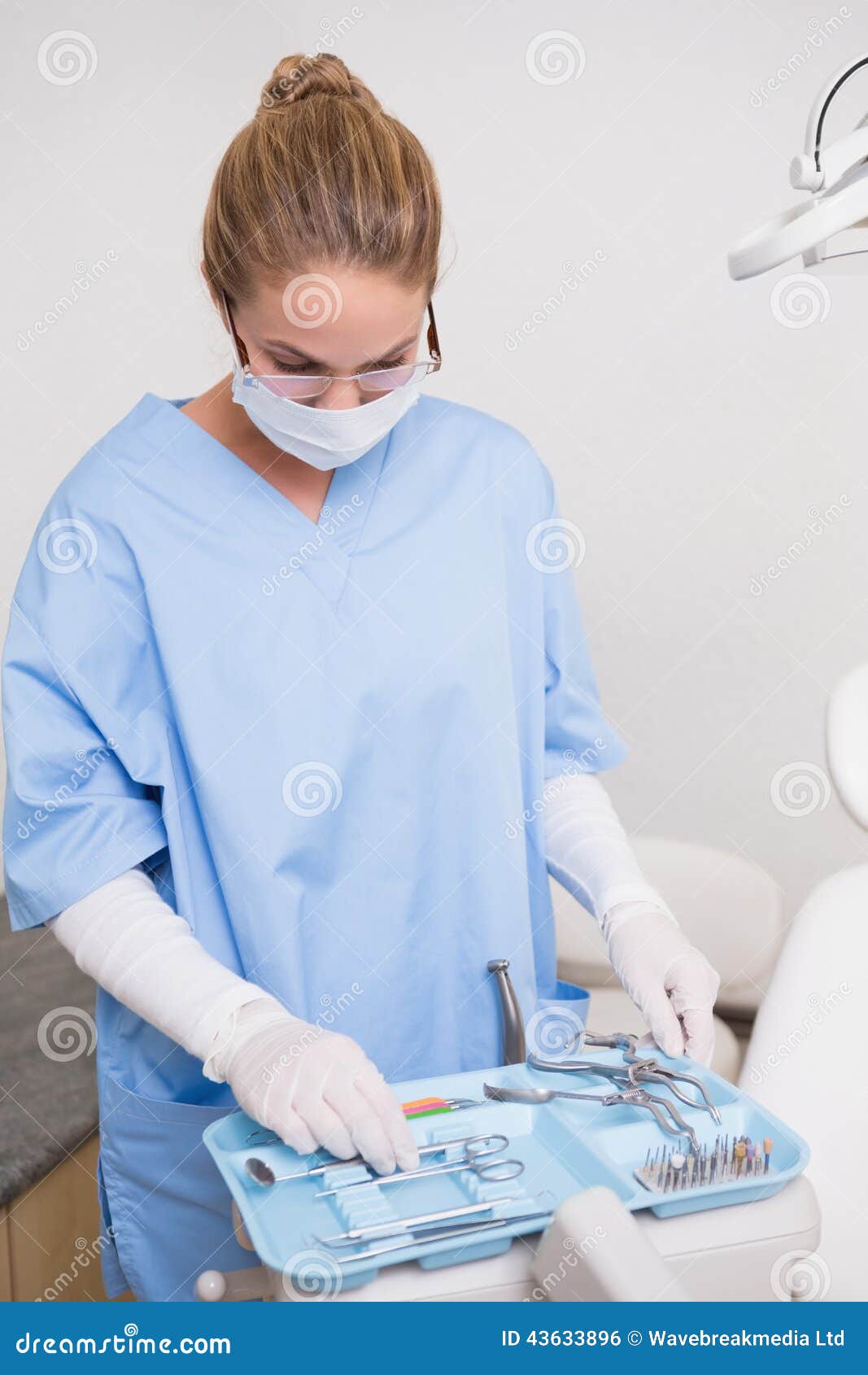Dentist in Blue Scrubs Looking at Her Tools Stock Photo Image of