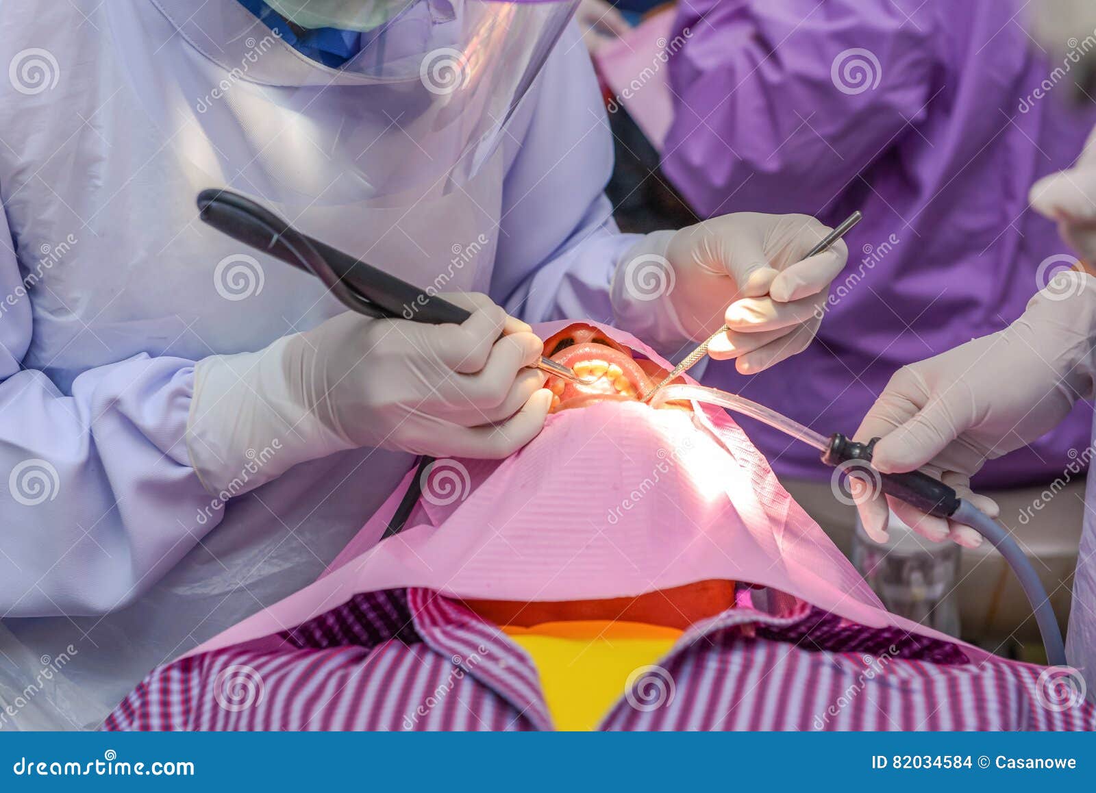 Dentist Cleaning the Teeth Patient with Ultrasonic Tool. Stock Photo