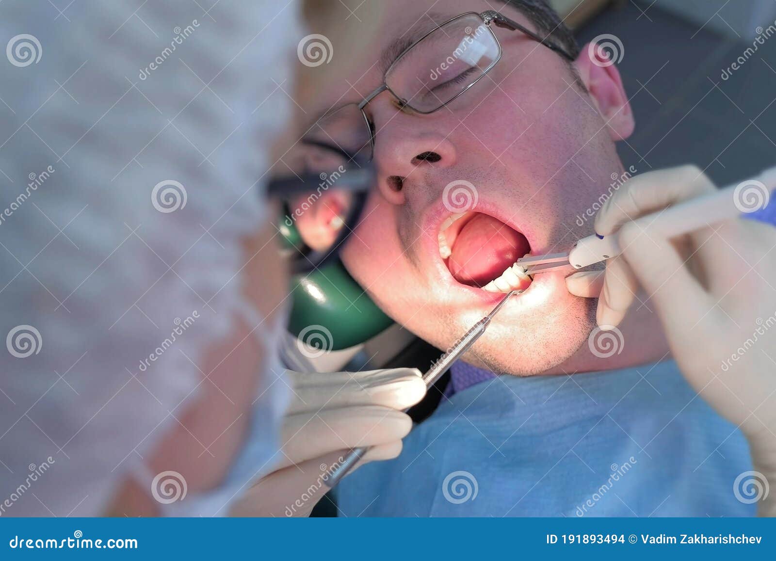Dentist Examining Patient Gums with Probe Using Method of Computer Diagnostics. Stock Photo