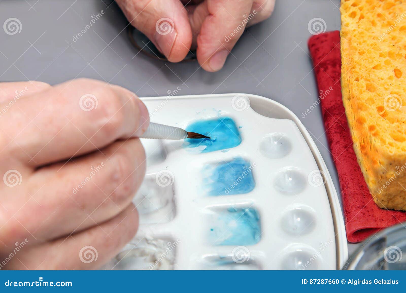 Dentist Hand with Brush on Ceramic Glaze for Dental Model Stock Photo