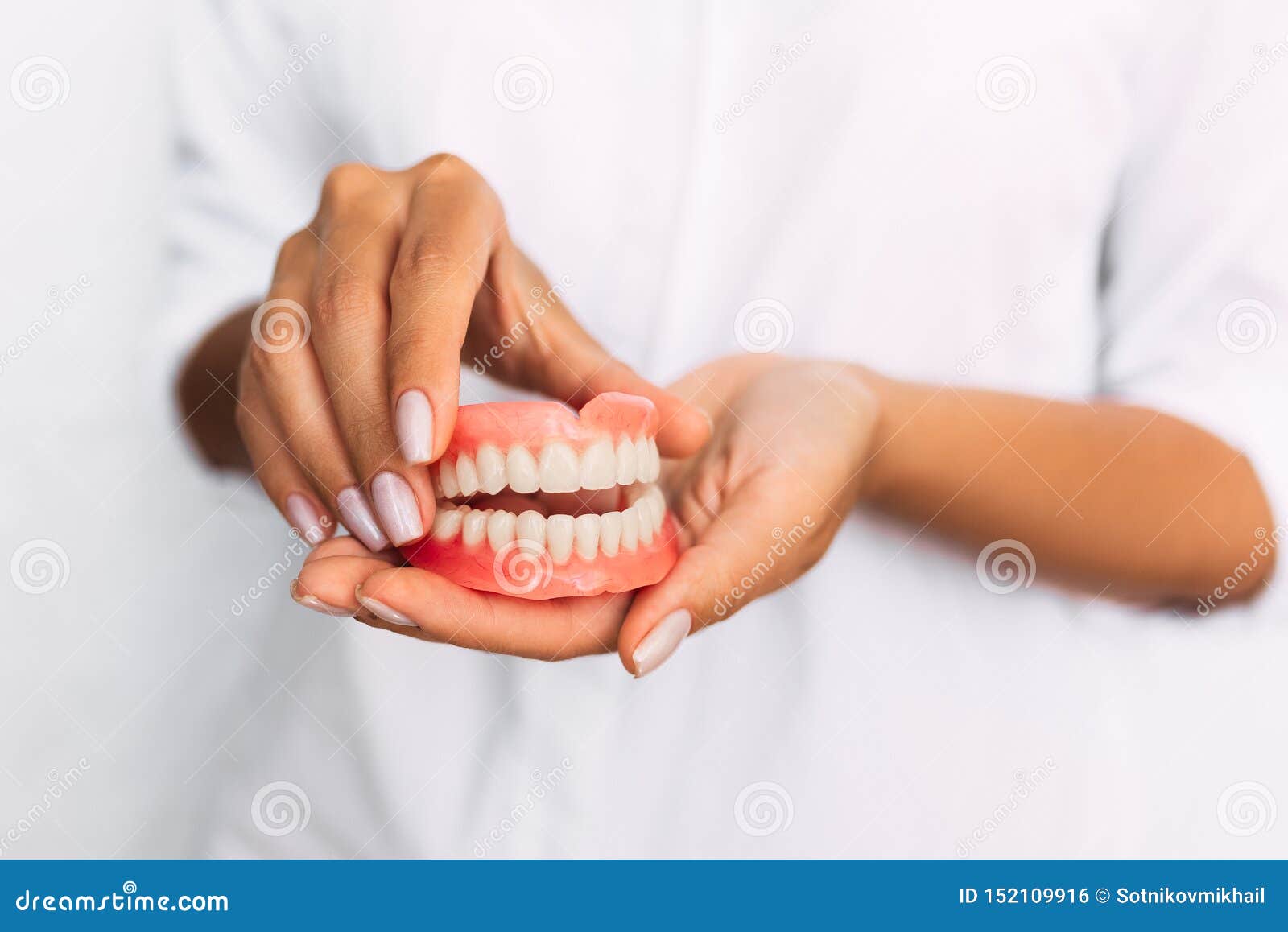 the dentist is holding dentures in his hands. dental prosthesis in the hands of the doctor close-up. front view of complete