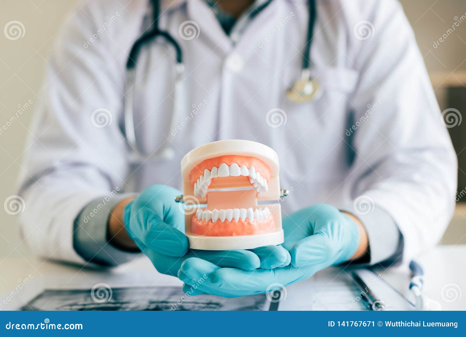 dentist holding dentures in office room