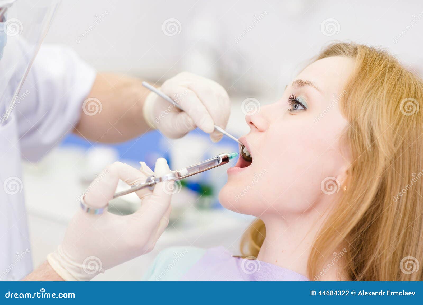 Dentist Holding a Syringe and Anesthetizing His Patient Stock Photo