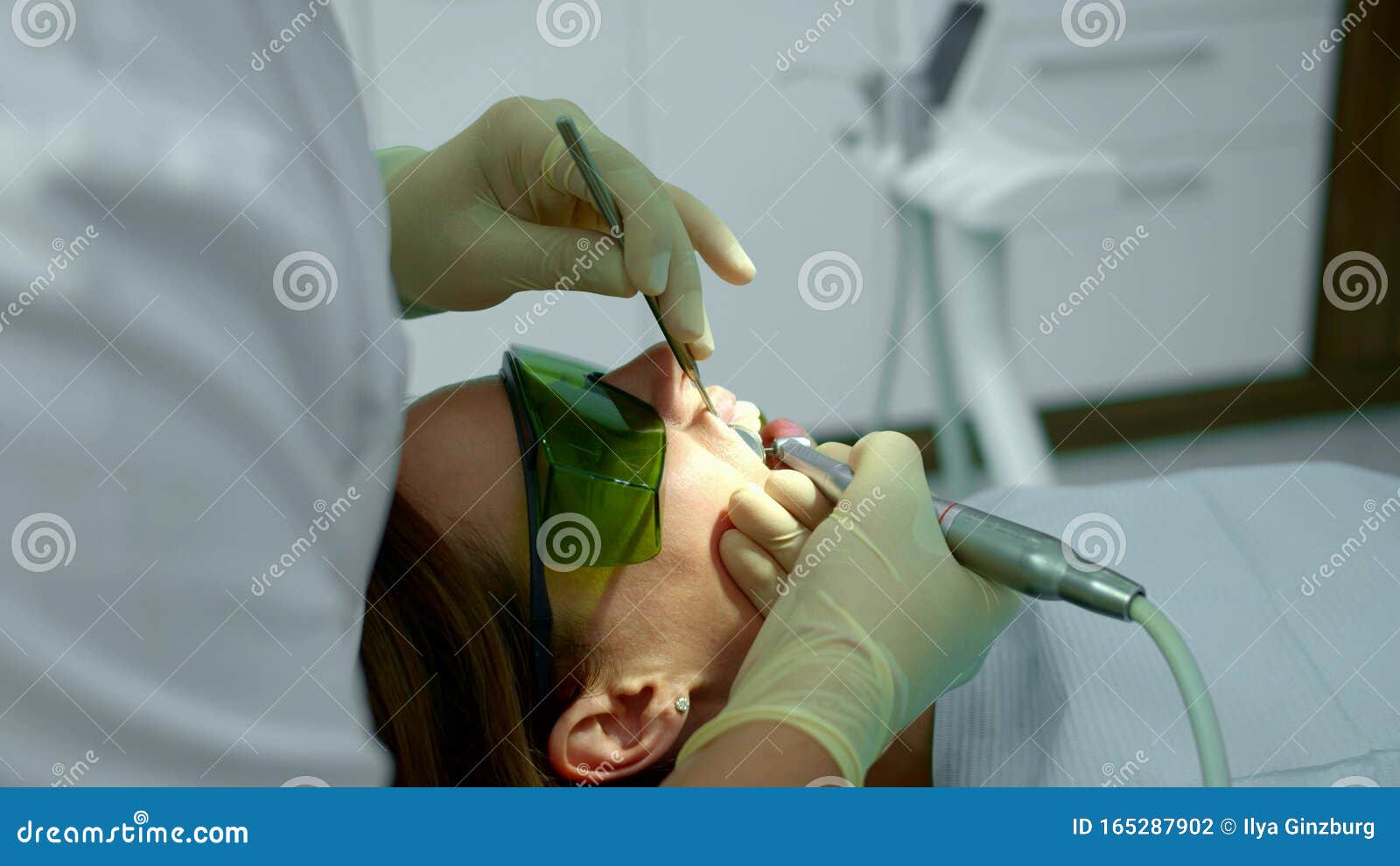 Dentist Holds Patients Upper Lip and Brushes Her Teeth Stock Photo