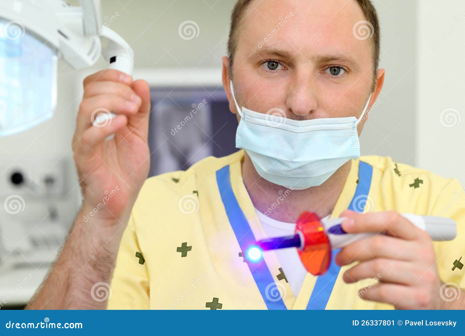 dentist holds ultraviolet curing light tool