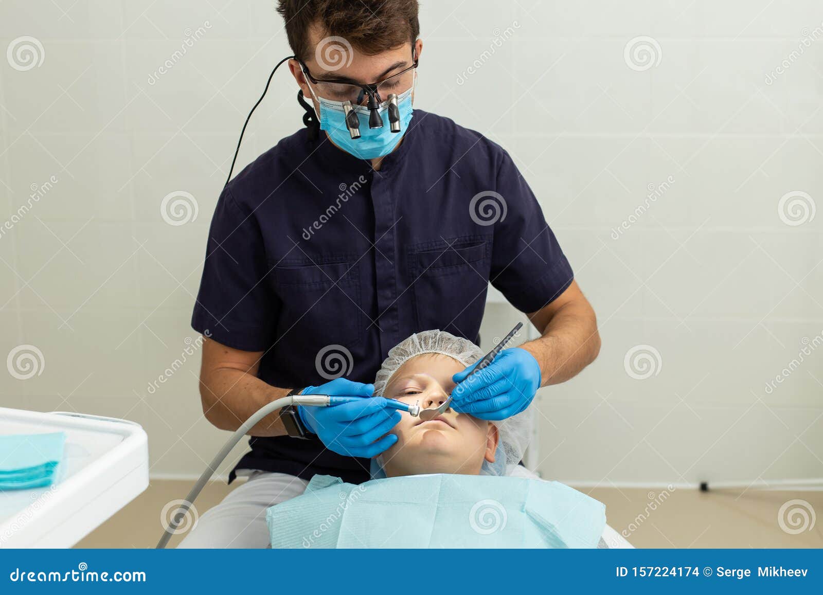 Dentist in Microscope Glasses Preparing for Operation Stock Photo