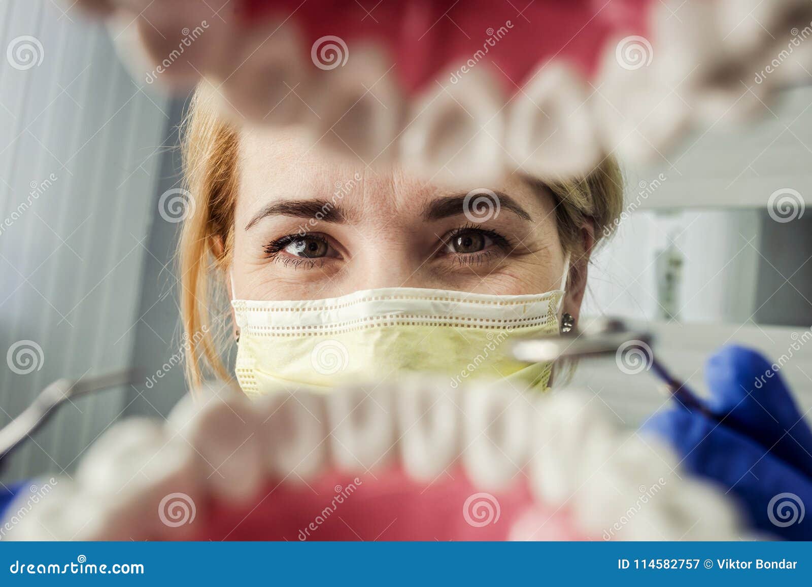 dentist over open patient`s mouth looking in teeth. oral care. i