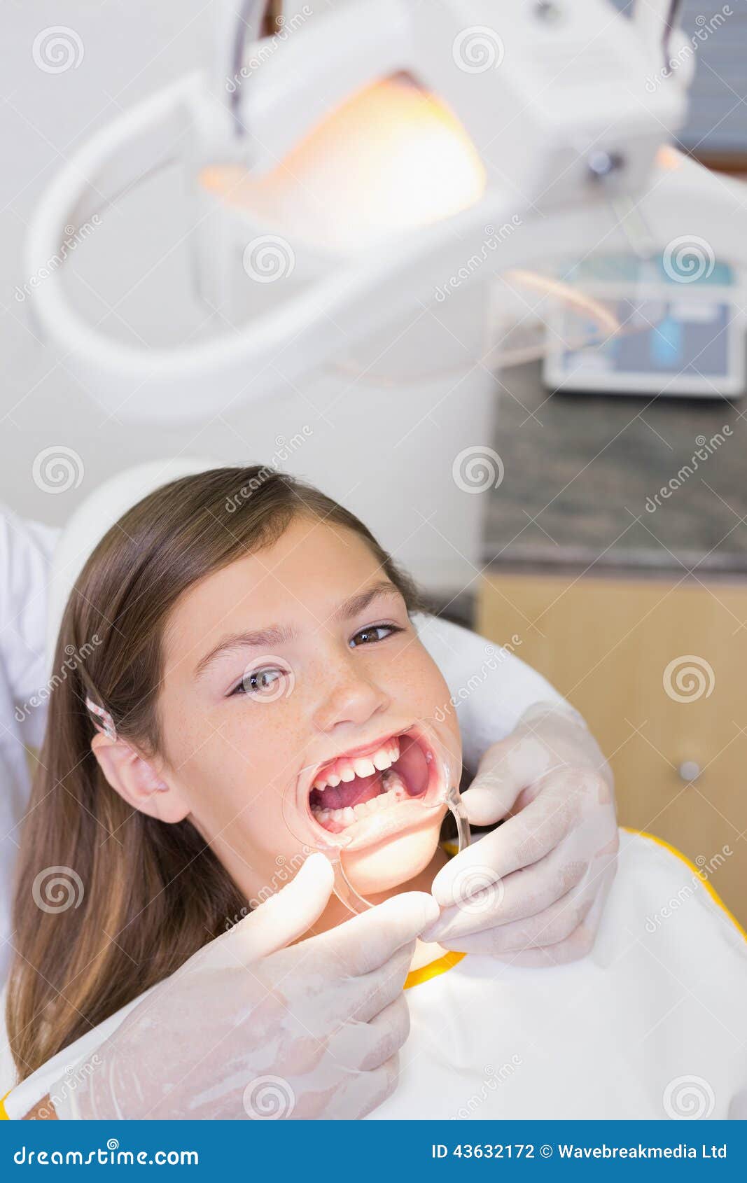 Dentist Putting Mouth Retractor On Little Girl Stock Photo - Image