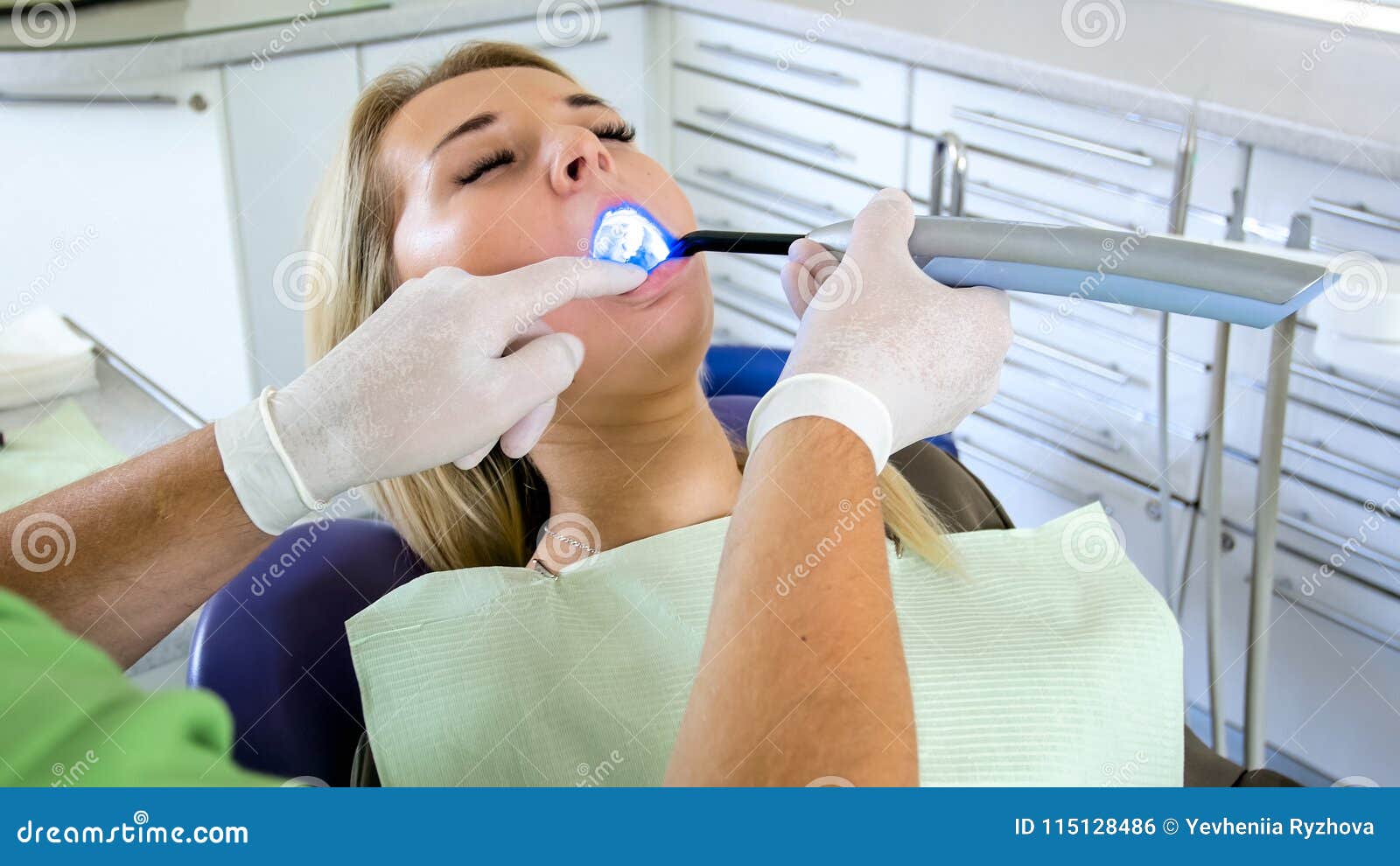 dentist using dental curing uv light lamp for treatment