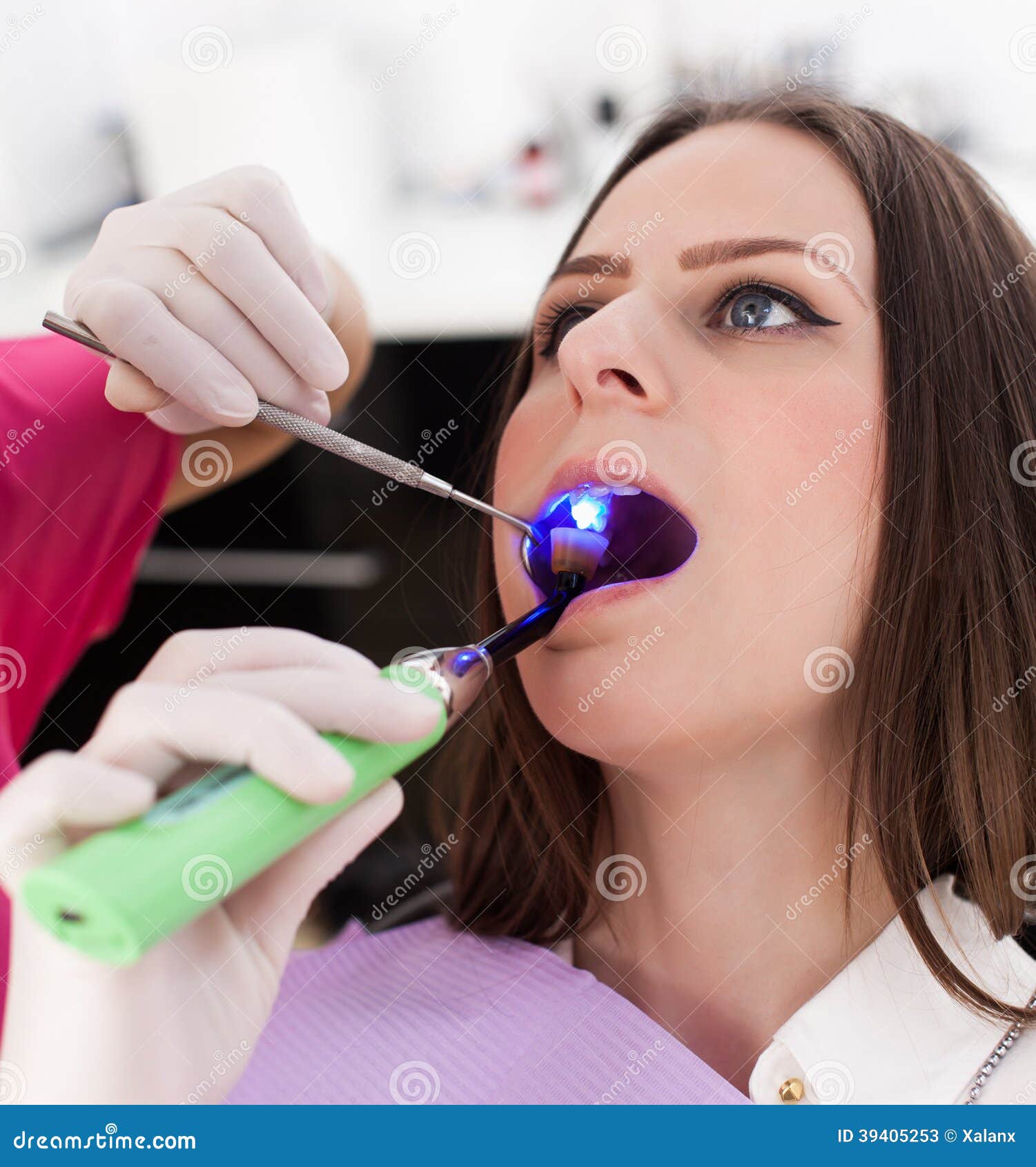 Dentist Using Ultraviolet Light on a Fill of Patient S Cavity Stock