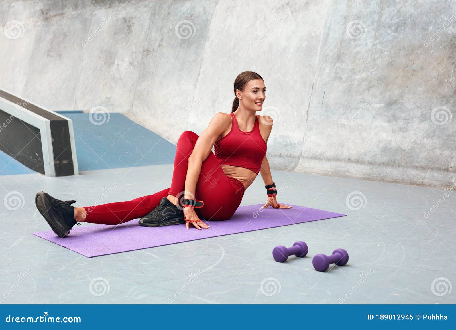 Deporte. Mujer Estirando Sobre Alfombra De Yoga Antes De Hacer Ejercicio.  Gimnasia Femenina Con Fuerte Cuerpo Muscular En Ropa Dep Imagen de archivo  - Imagen de afuera, lifestyle: 189812945