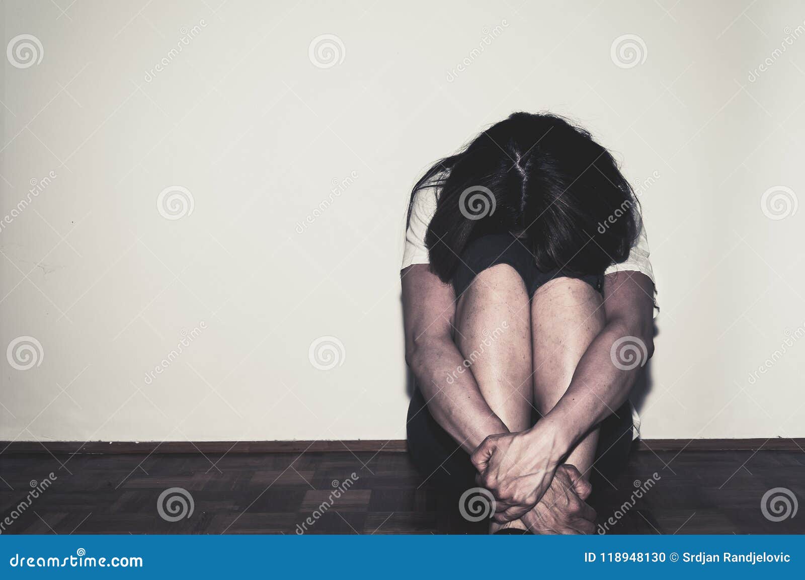depressed and lonely girl abused as young sitting alone in her room on the floor feeling miserable and anxiety cry over her life,