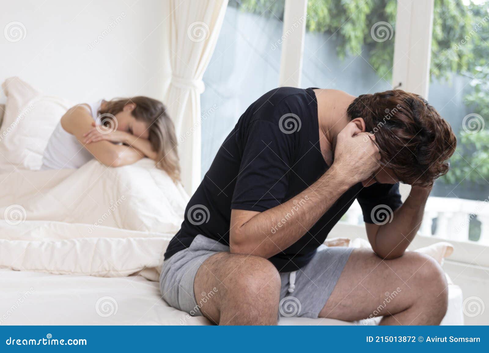 Depressed Man Sitting on the Edge of the Bed in Bedroom image