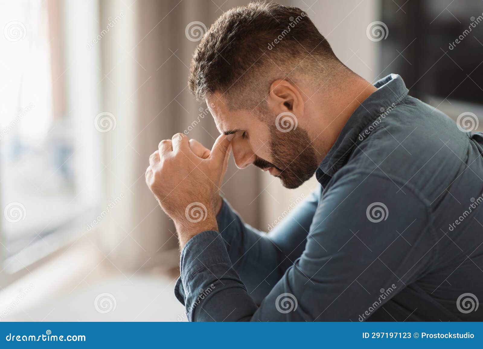 depressed middle aged man grapples with grief sitting at home