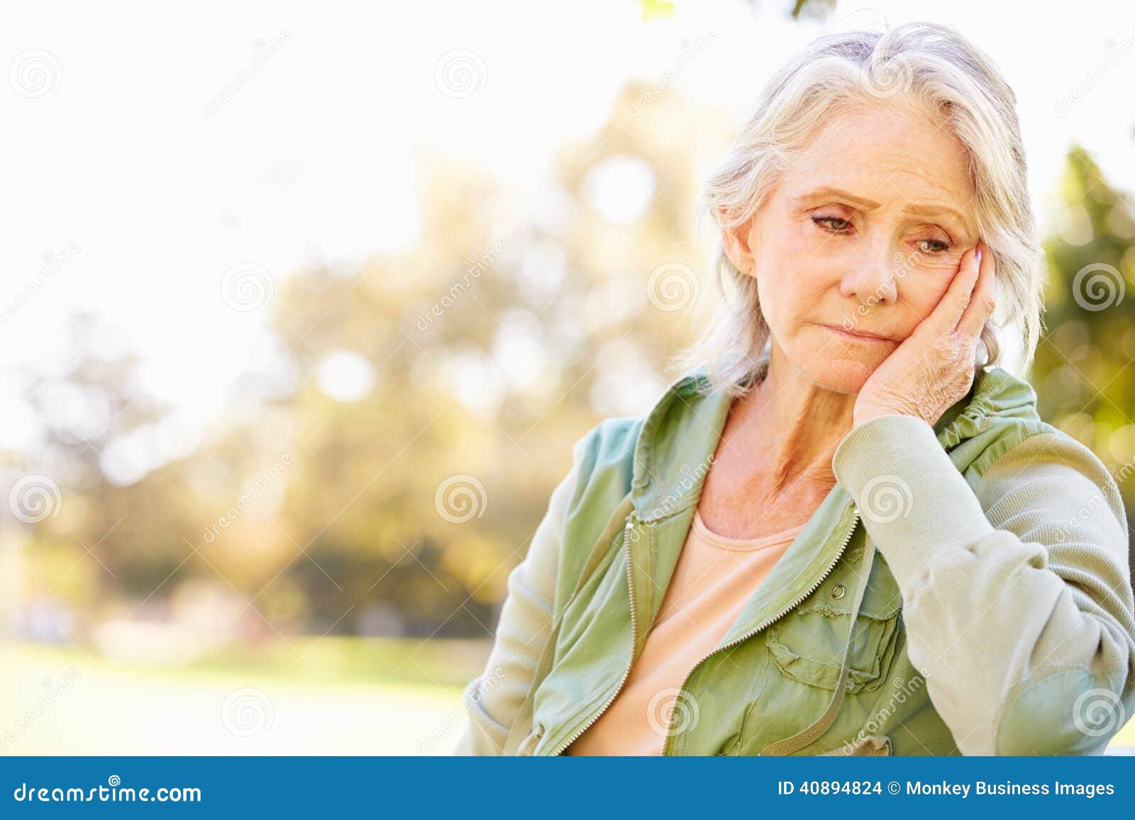 depressed senior woman sitting outside