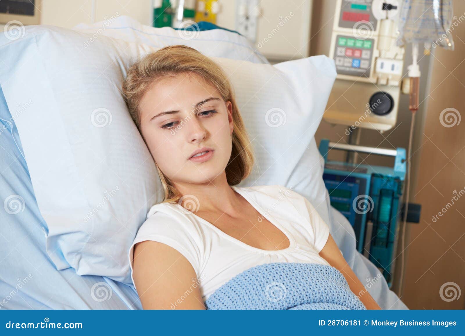 depressed teenage female patient lying in hospital bed