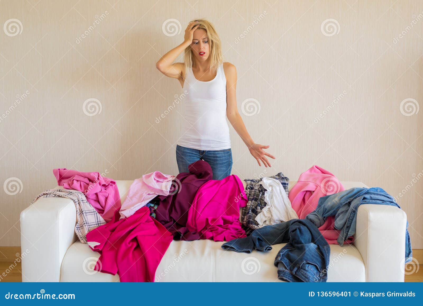 woman looking at messy stack of clothes at home