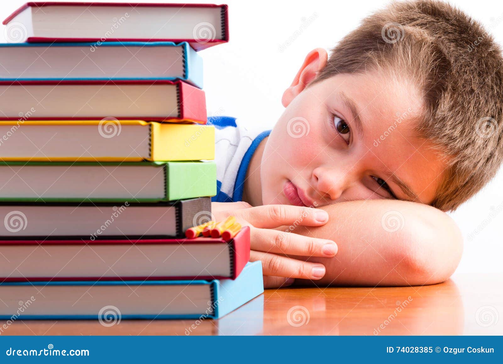 depressed young schoolboy eyeing his textbooks