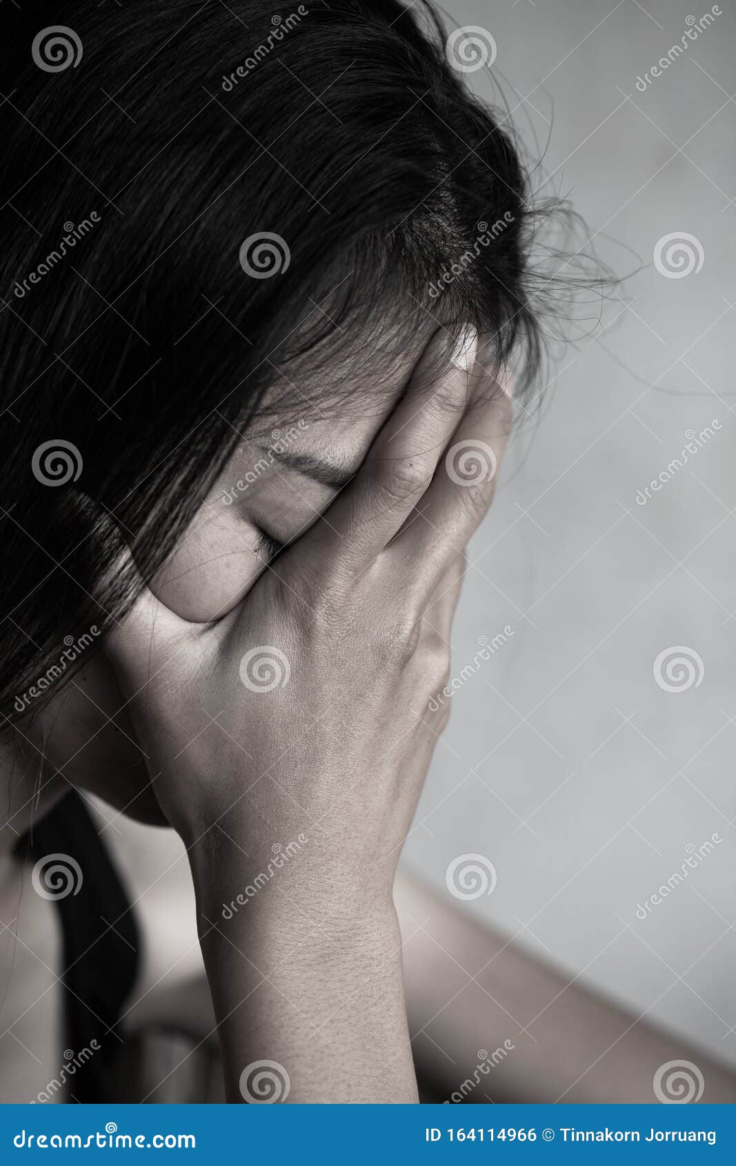 depression or domestic violence concept, desaturated grunge image of a very sad adult woman crying