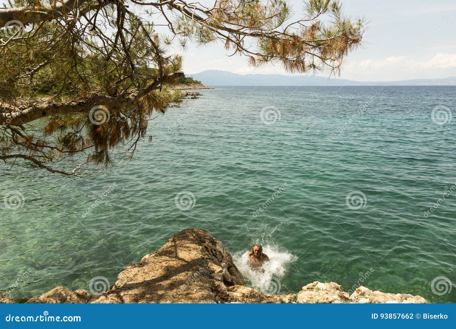 Der Mann herein springend zum Meer. Bemannen Sie zum Meer vom Felsen in Insel Krk auf adriatischem Meer, Kroatien herein springen