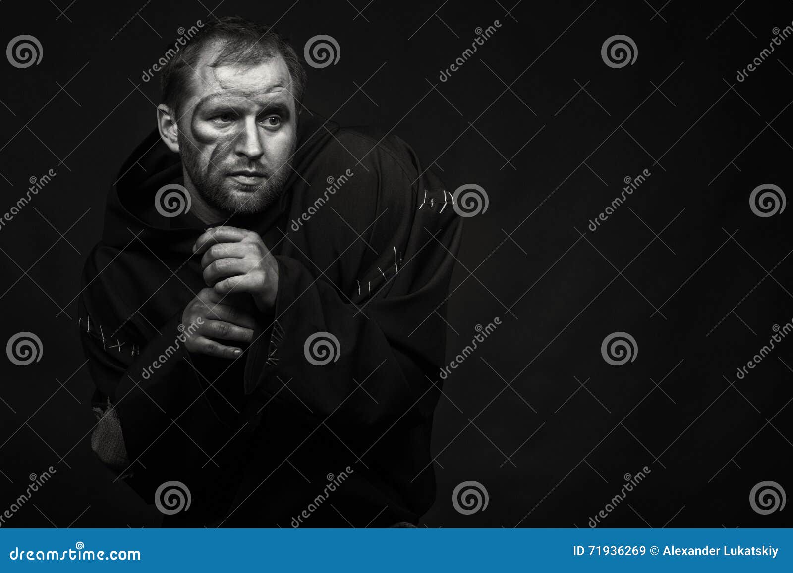 Der Mann im Bild eines Mönchs auf einem dunklen Hintergrund Berufstheatermake-up und Kostüm Berufsfungieren Fotos für Zeitschriften, Poster und Website