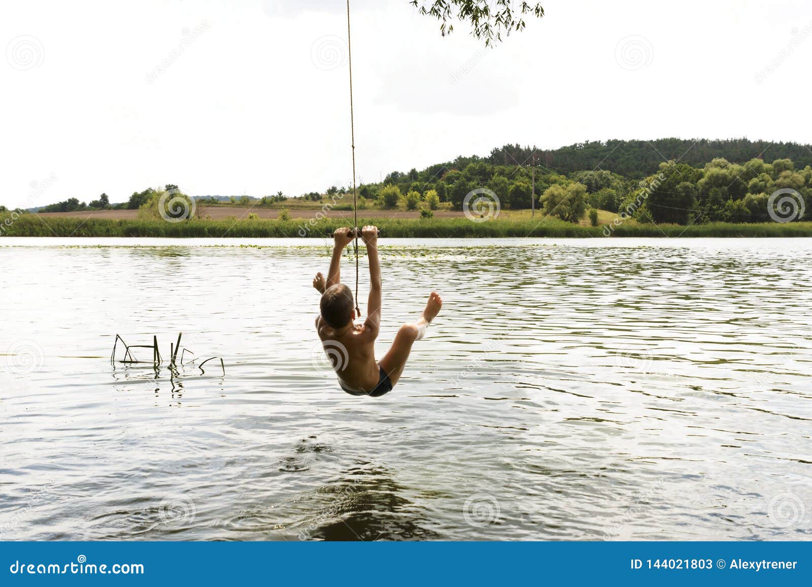 Der Teenager Springend In Den Fluss  Vom Schwingseil Am 