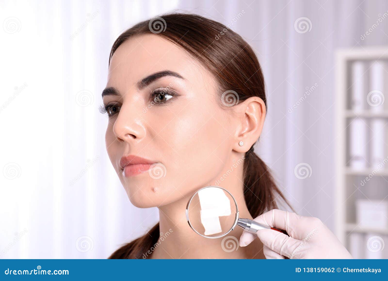 Dermatologist Examining Patient With Magnifying Glass Stock Photo