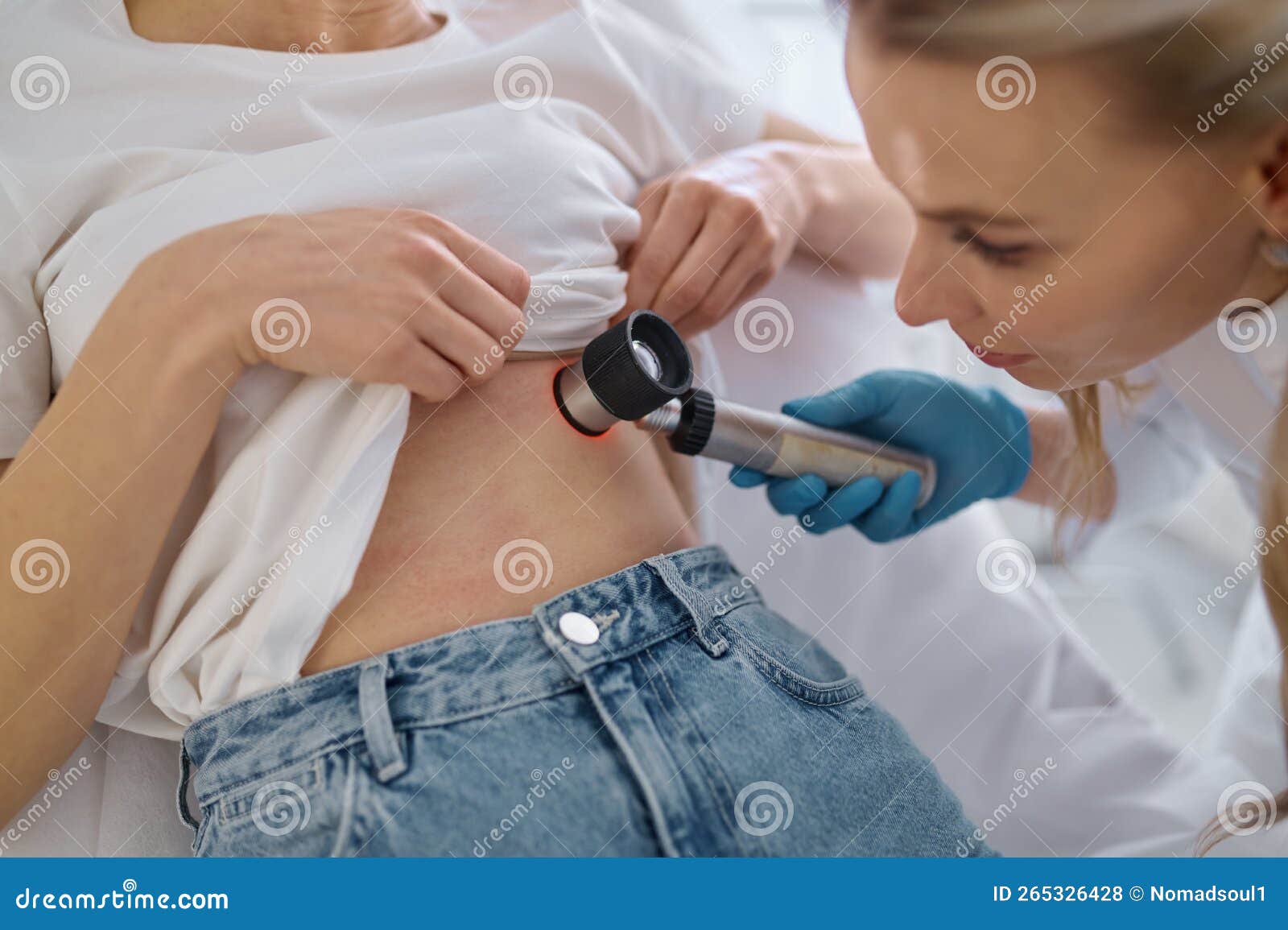 Dermatologist Examining Patient With Magnifying Glass In Clinic Stock