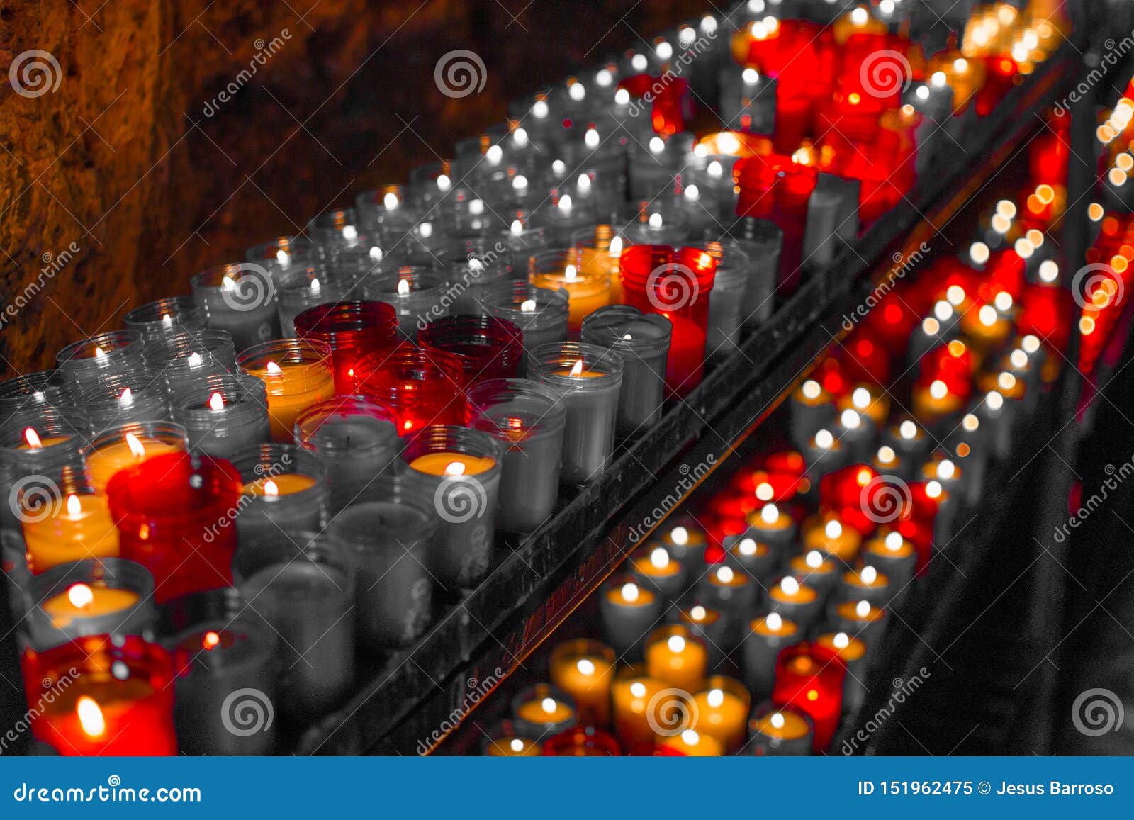 desaturated red close up of colorful candles in a dark spiritual scene. commemoration, funeral, memorial. religious ism