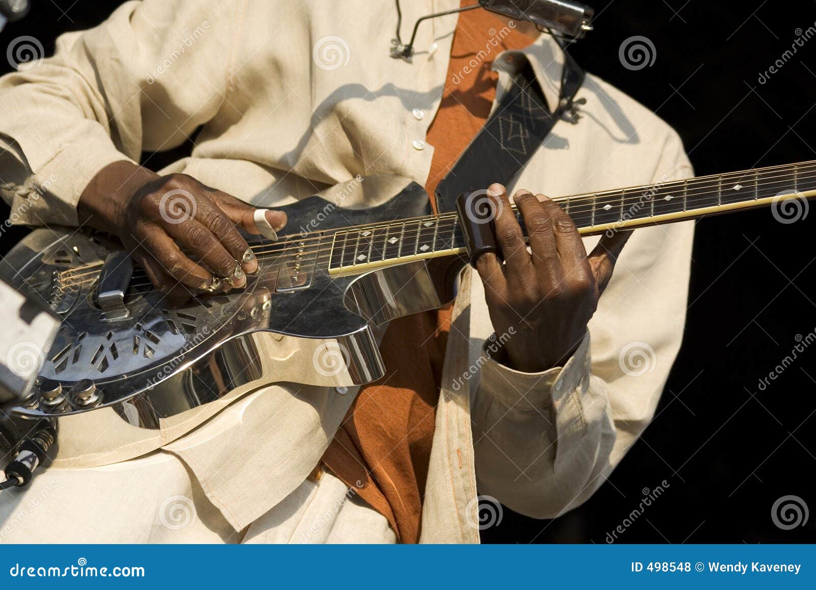 Desempenho de solo. Mãos pretas que jogam uma guitarra de aço