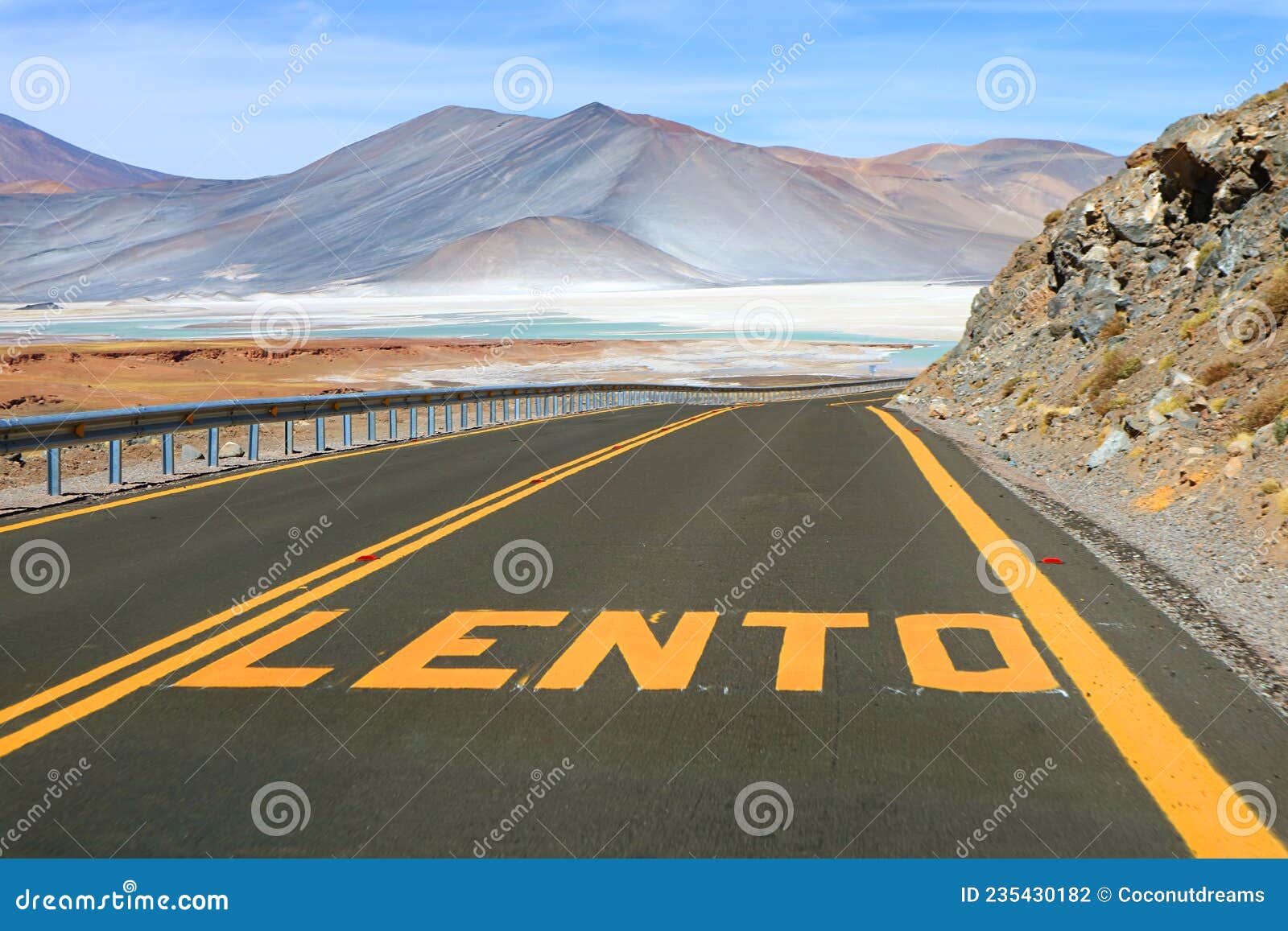 desert road with the word lento means slow in spanish along salar de talar salt lakes in los flamencos national reserve, chile