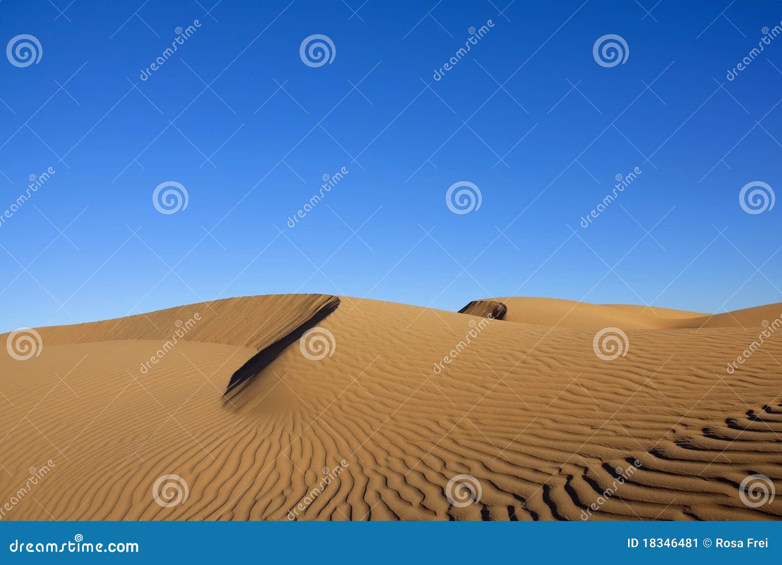 Sand dune against blue sky - a Royalty Free Stock Photo from Photocase
