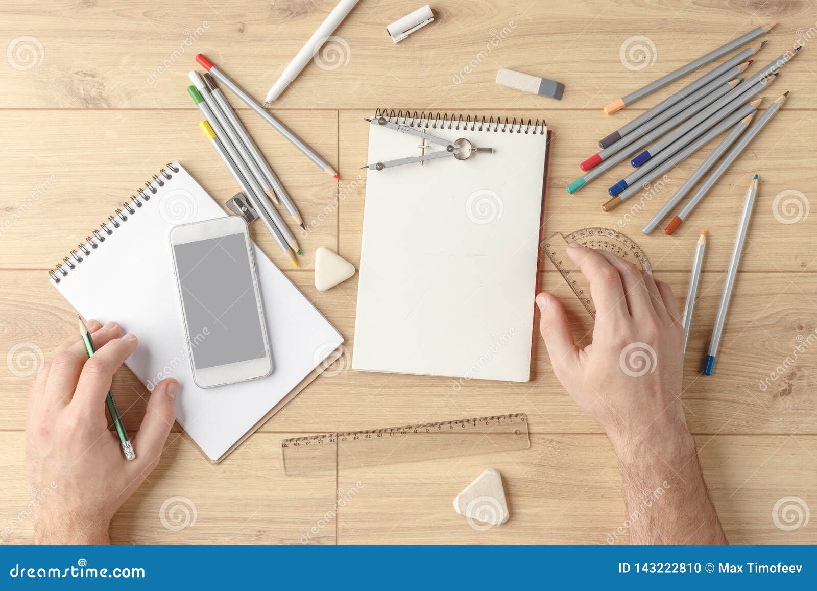 The Designer Draws A Sketch In A Notebook On A Wooden Table