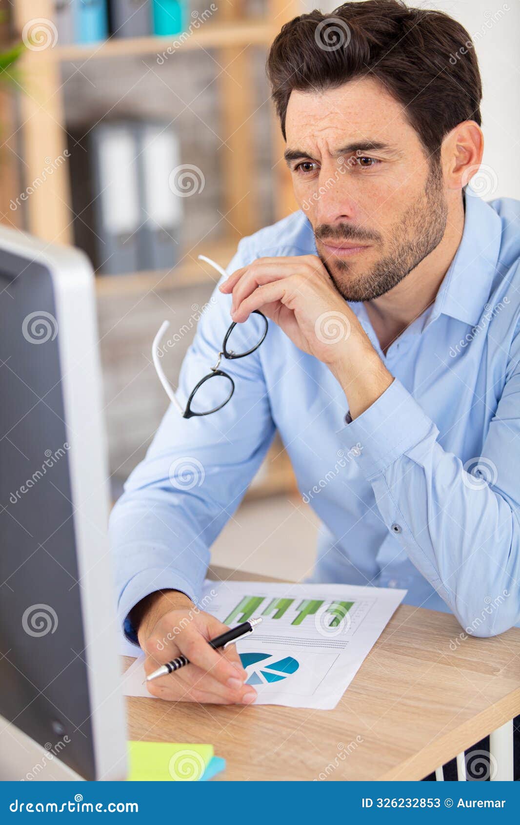 er working with computer and printed graphics