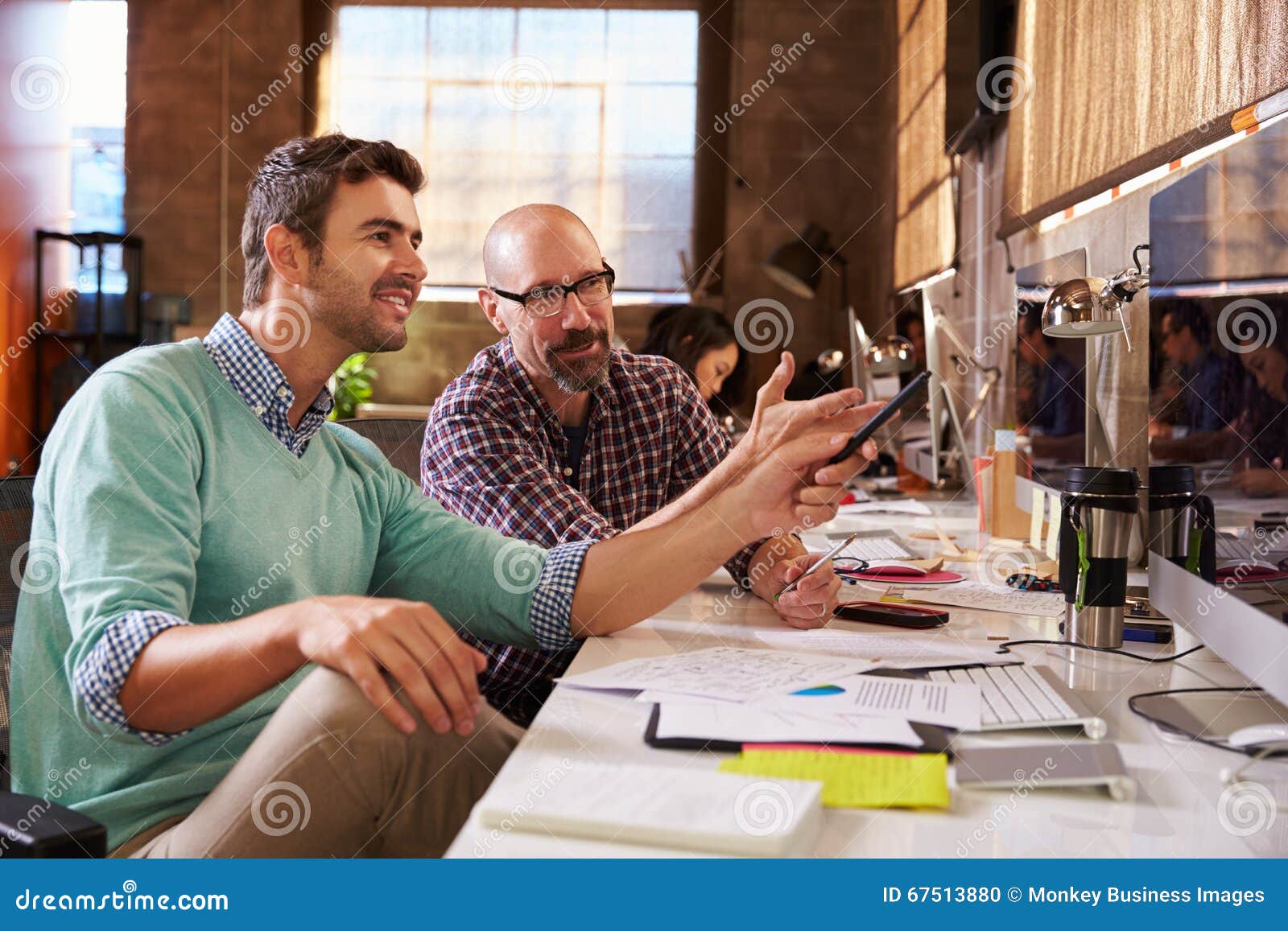 Designers Working Together at Desks in Modern Office Stock Photo