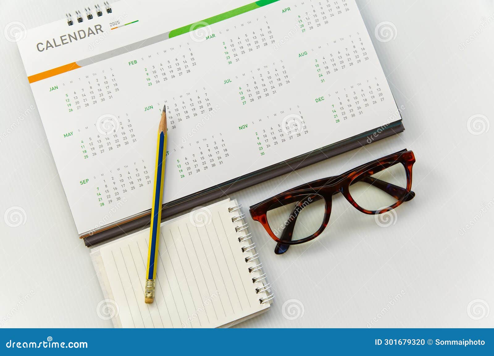 Desk Calendar 12 Months Year 2025 with Glasses Notepad and Pencil Stock