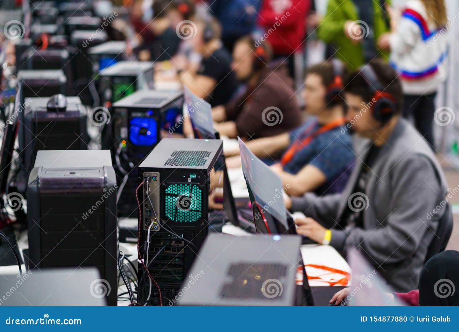 Desktop computers and playing people on a gaming tournament. eSport competition concept.