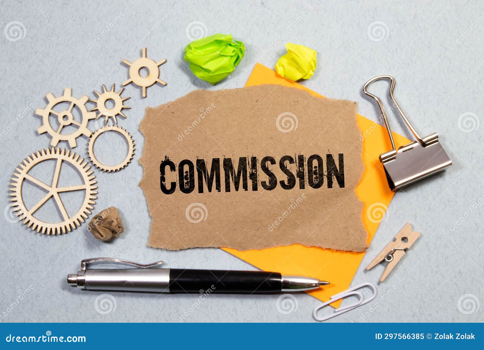 on the desktop are notebooks, a pen and a red folder for papers with the text commission. business concept