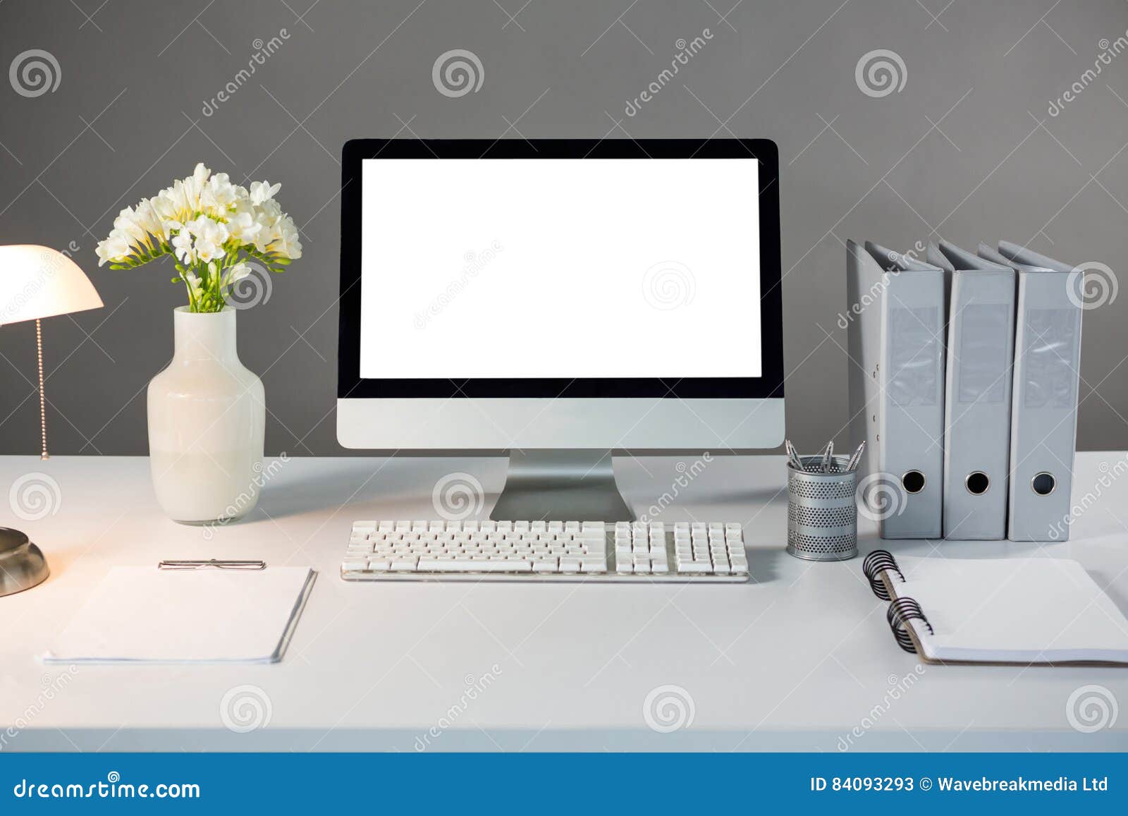 desktop pc with flower vase and files