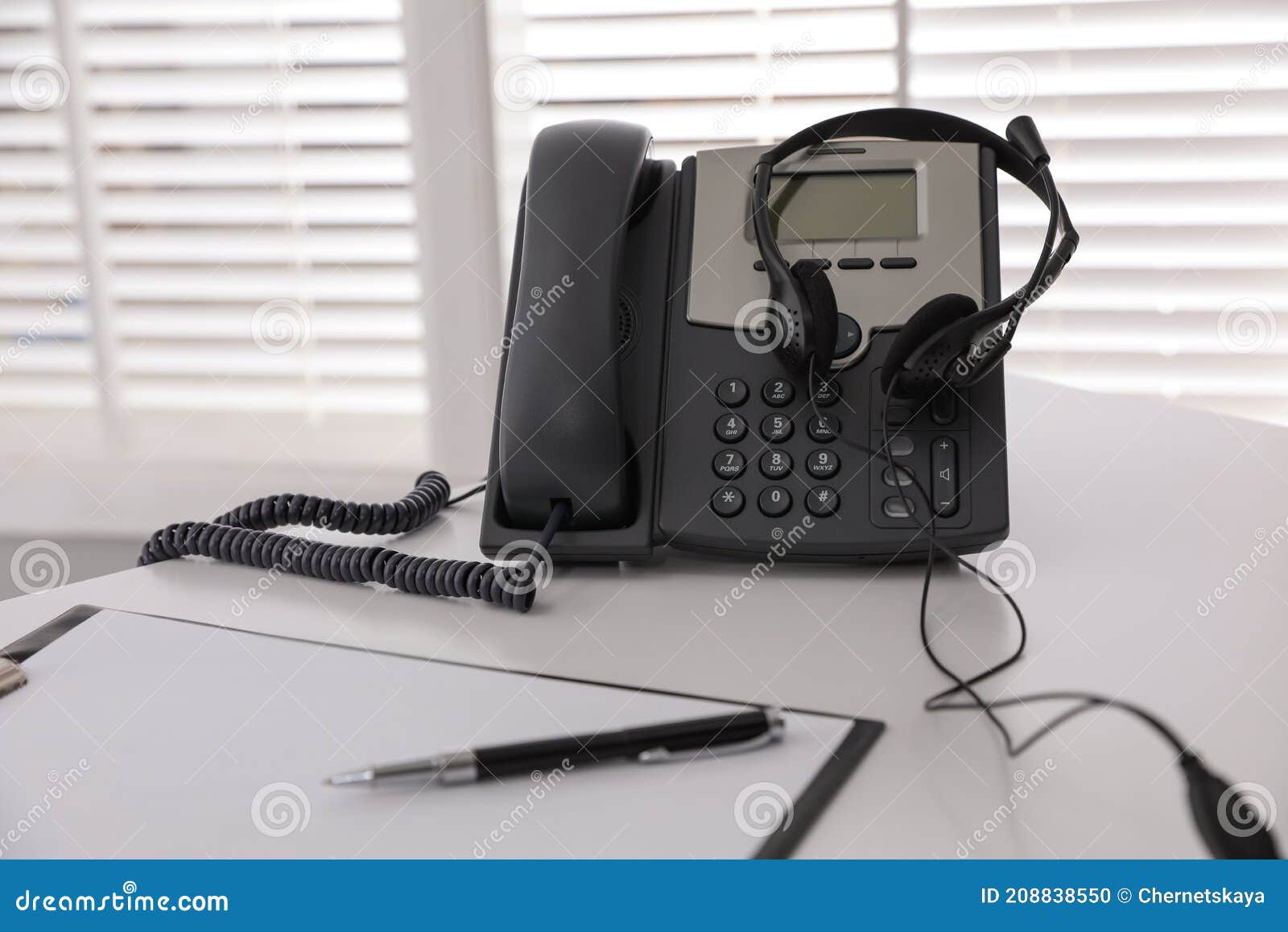 Desktop Telephone with Headset on White Table in Office. Hotline