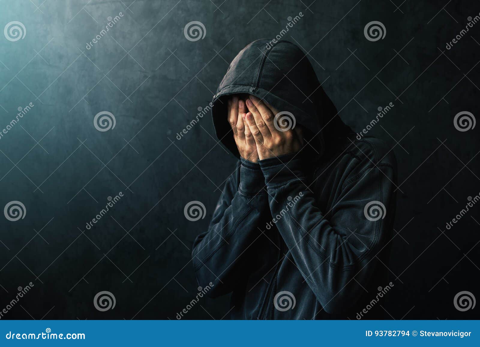 desperate man in hooded jacket is crying