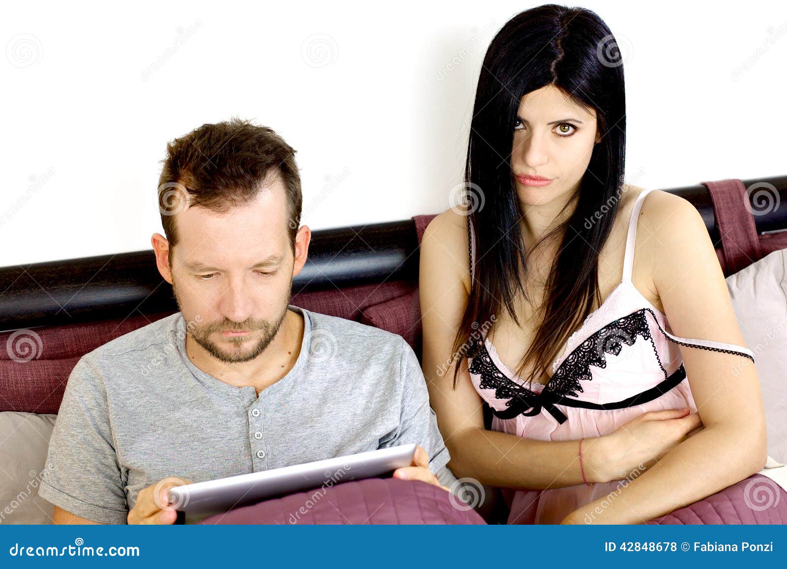 Desperate Wife with Man Addicted To Tablet Stock Photo