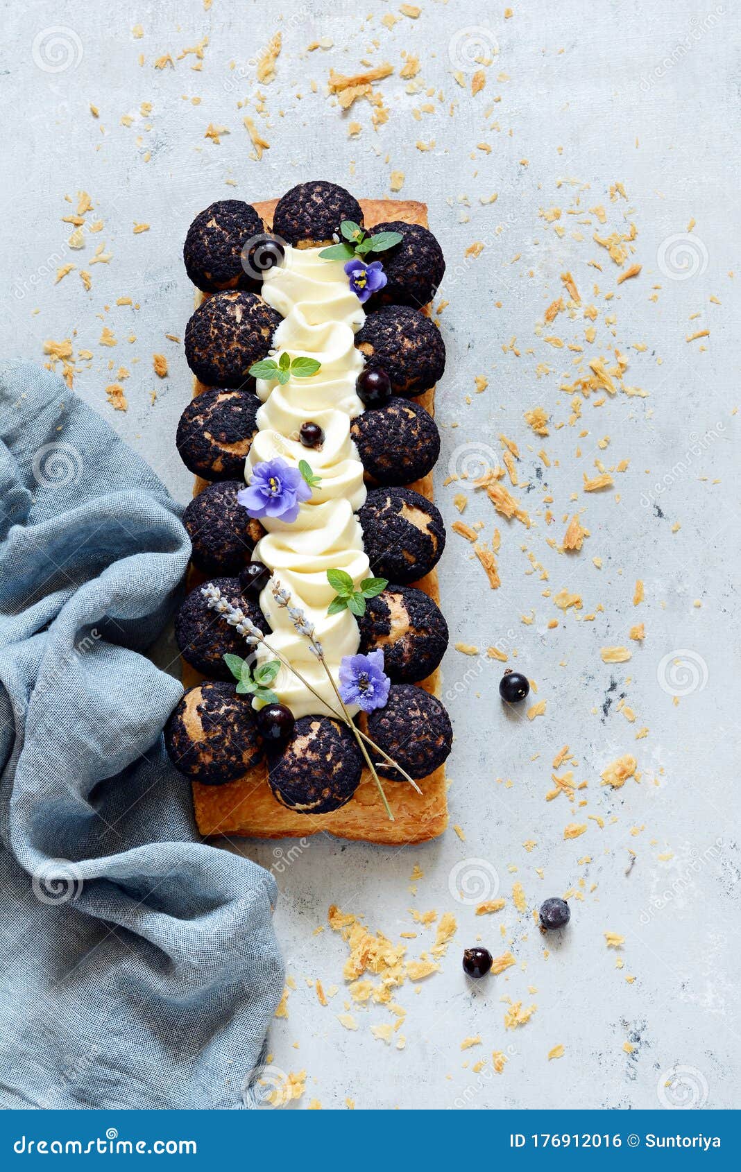 dessert saint onore. berry pie. puff pastry tart with profiteroles, butter cream, black currant jam with fresh mint, lavender