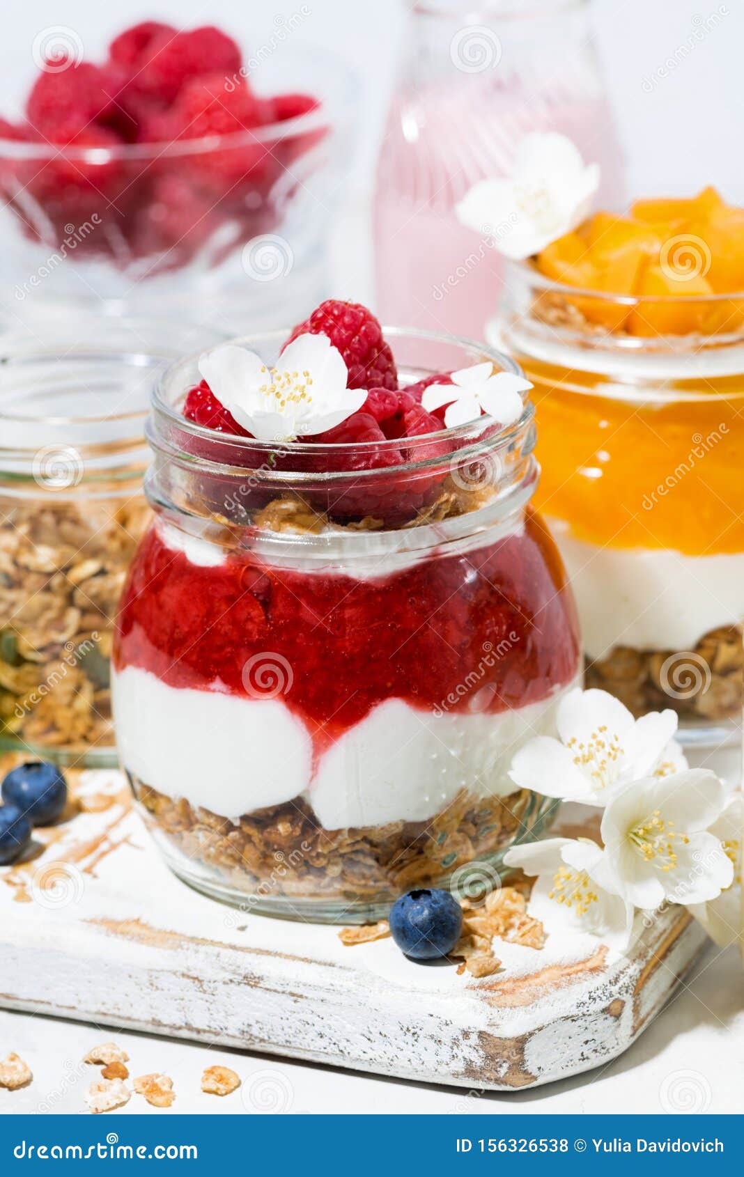 Desserts with Muesli, Fresh Berries and Fruit in Jars, Vertical Closeup